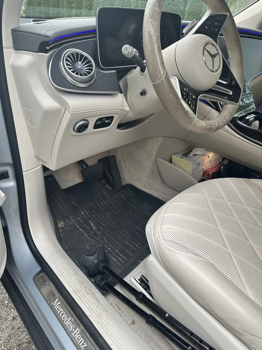 Before: driver side of a cream interior with a muddy floor mat, a grimy steering wheel and a dusty door sill